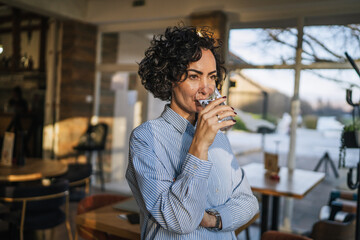 Woman drinking water enjoying a healthy break in cafe