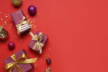 Beautiful composition with different Christmas decorations and gift boxes on red background