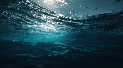A beautiful blue ocean with sunlight reflecting off the water. Scene is serene and peaceful, as the calm water and bright sunlight create a tranquil atmosphere