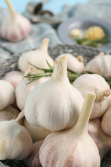 Bowl with fresh garlics on blue background, closeup