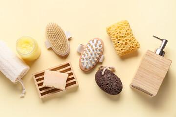 Composition with massage body brushes, soap bar, bottle and jar of cosmetic products on beige background, closeup