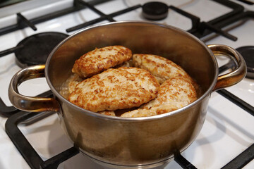 Meat cutlets are stewed in saucepan after being fried in a frying pan. Cooking