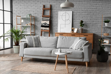 Interior of living room with wooden ladder, sofa and shelf units