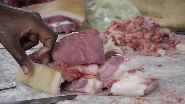 Hand deftly slicing through fresh, succulent meat