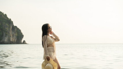 Stylish casual female enjoying sunset at tropical beach