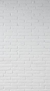 A full frame of a clean white painted brick wall background, highlighting the uniform texture of individual bricks and mortar joints with subtle light and shadow.