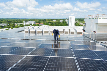 Engineer checking inspection solar cells on the roof.Technician maintaining solar panels on blue sky and white clouds background.Solar photovoltaic panel system and saving energy with clean powers.