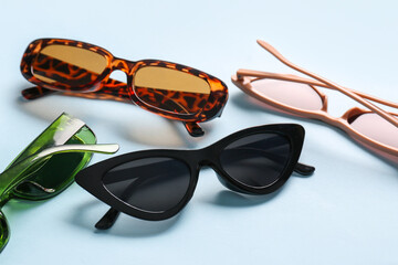 Different modern eyeglasses on blue background, closeup