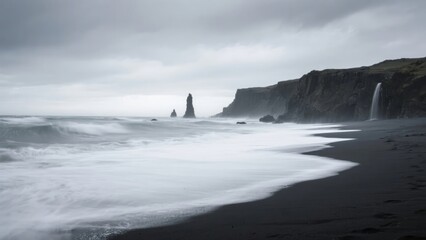 Stormy coastal scene with black sand beach, sea stacks, and a waterfall cascading from cliffs under overcast skies