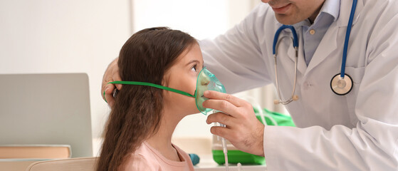 Little girl with doctor using nebulizer in clinic
