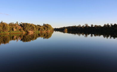 Reflection of trees on the calm glass-like surface of the Burdekin River near Charters Towers in Queensland, Australia © Tammy Walker