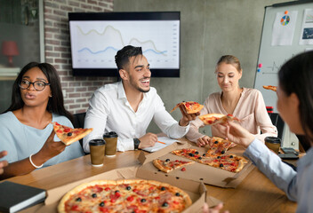Group of cheerful coworkers share pizza and laughs during their lunch break. They engage in lively conversation while enjoying takeout in the boardroom, creating a friendly atmosphere.