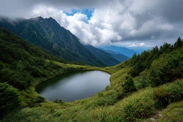 Mountain lake nestled amid green hills under a cloudy sky