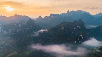Breathtaking sunrise over Khao Sok National Park in Thailand with misty mountains
