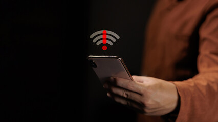 Person holding smartphone with disconnected wifi signal and red alert icon.