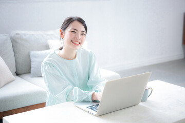 座るパソコンを操作する女性　タイピングするカメラ目線