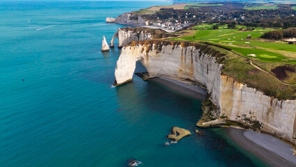 Fototapeta premium Aerial drone view of picturesque coastal limestone cliffs and the English Channel town of Etretat, France