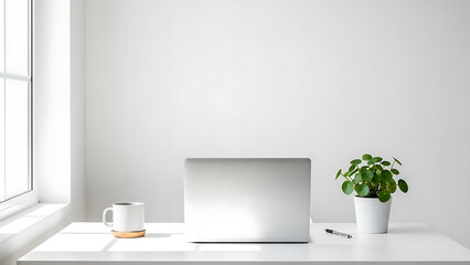 Minimalist white desk with laptop, plant, and coffee mug. Bright natural light creates a clean, modern home office workspace for productive remote work