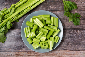 Fresh green cut celery on wooden table.