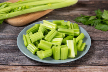 Fresh green cut celery on wooden table.