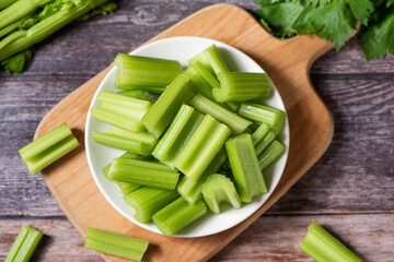 Fresh green cut celery on wooden table.