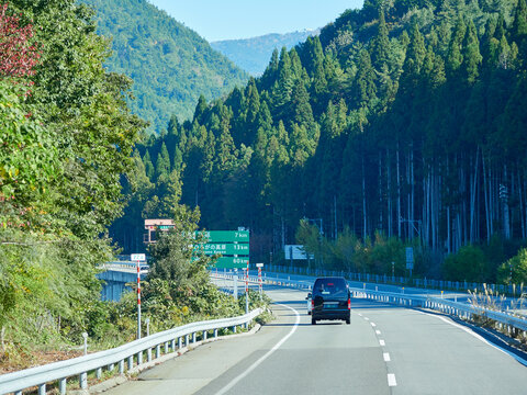 秋の岐阜県内山間部の高速道路の風景