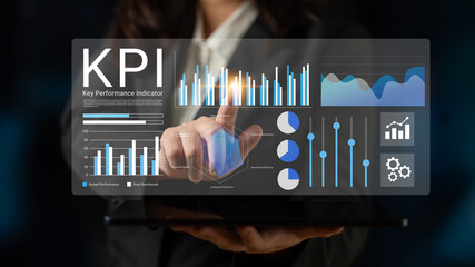 A business professional engages with a digital interface showing key performance indicators. This image highlights modern analytics and data visualization in a corporate setting. Gantry