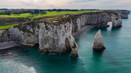 Aerial drone view of picturesque coastal limestone cliffs and the English Channel town of Etretat, France