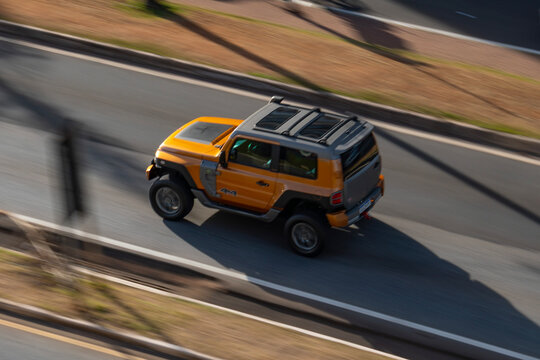 Yellow Troller T4 driving fast on asphalt, Brazilian off-road jeep high angle panning