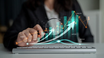 Business professional analyzing data trends with magnifying glass over keyboard in modern office setting, digital graphs displaying growth metrics Scalp.