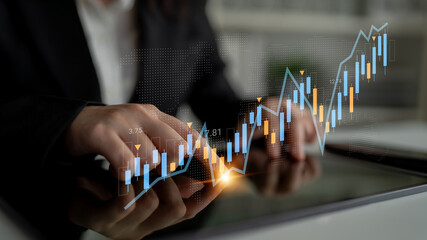 A business professional uses a tablet to analyze stock market graph and financial data in a modern office setting. The image highlights growth and investment strategies. Gantry