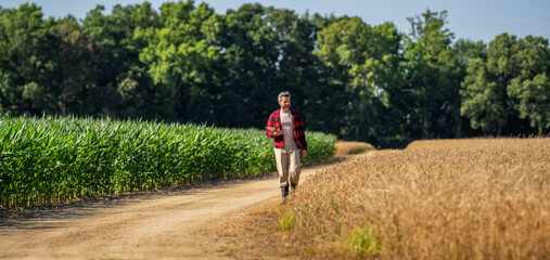 Technology of modern agriculture. Farmer man working on field with tablet. Agronomist farmer visit...