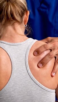 A close-up view of a chiropractors hands performing an adjustment on a womans upper back and shoulder area, focusing on spinal alignment and muscle relief.