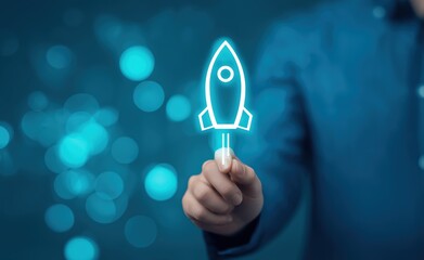 Hand holding glowing rocket launch icon on blue bokeh background for startup business and technology innovation concepts representing growth