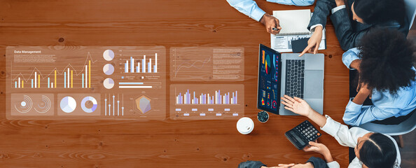 A professional team engages in a data management meeting, utilizing charts and graphs on a laptop to drive insights and foster collaboration in a modern office setting. Gantry