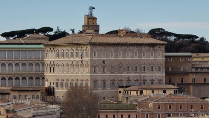 Vatican City &ndash; 12 January 2025. The Apostolic Palace stands with aligned windows and a muted fa&ccedil;ade, framed by nearby Vatican buildings and umbrella pines in the distance.