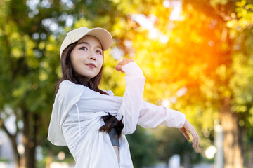 Beautiful confiden asian woman make stretching exercises for arms in green park relax in nature. Portrait Asian girl with friend do serene sincere peaceful in morning park sportswoman wellness health.