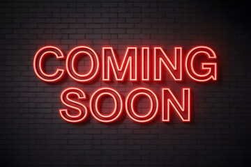 Obraz premium Vibrant 'COMING SOON' neon sign in bold red against a textured gray brick wall, creating a striking industrial backdrop with dramatic lighting effects.