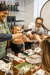 Diverse women friends enjoying wine tasting experience and toasting