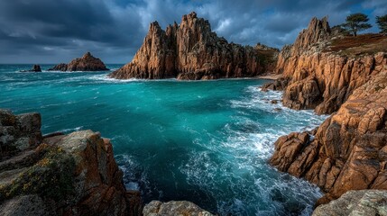 Obraz premium Dramatic Rocky Coastline Under Stormy Sky with Turquoise Waves
