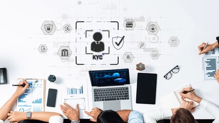 A diverse team collaborates in a modern workspace, focusing on KYC compliance using technology, data analysis, and financial management tools for effective outcomes. Raster