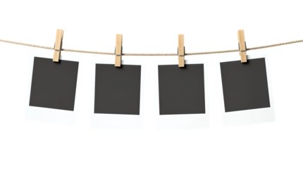 Four blank polaroid photos hanging from clothes pins