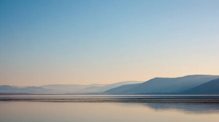 Fototapeta premium Springtime Coastline With Blue Water and Light Sky Showing Hills in the Distance During Early Morning
