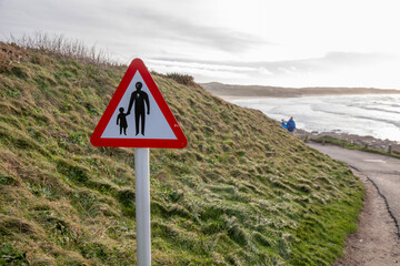 A pedestrian warning sign at Godrevy Beach in Cornwall, UK.