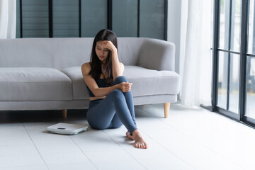 Sad woman with fat upset bored of dieting Weight loss fail  Fat diet and scale sad asian woman on...