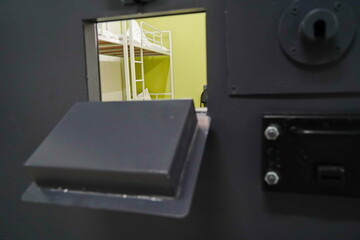 The bed linen is on the bed. A cell in the colony. View from the door window.