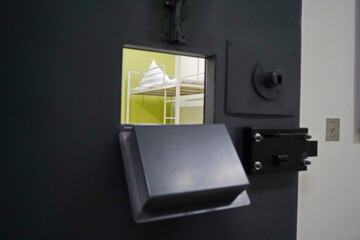 The bed linen is on the bed. A cell in the colony. View from the door window.