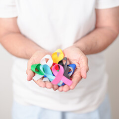 World cancer day, February 4. Elderly with colorful ribbons, blue, yellow, red, green, white, pink...