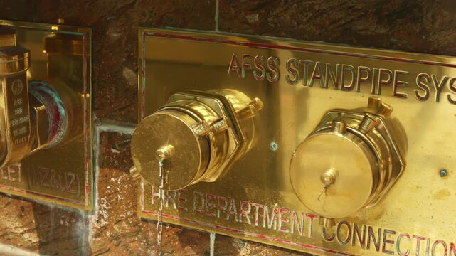 Inspecting brass pipe connectors, maintenance inspector examining corrosion on brass standpipe connectors, detail shot of brass pipe inlet and fire inspector checking seals against marble surface