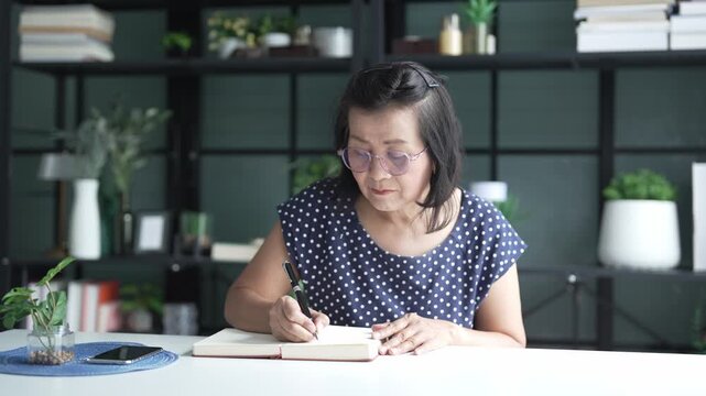 senior Asian woman Write a diary in a notebook